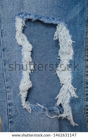 Jean texture, Close up texture of ripped destroyed torn jean or hole and threads on jean texture use for fabric background


