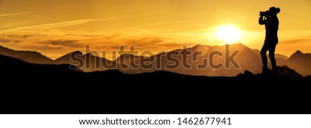 Photographer at sunrise in the mountains Silhouette