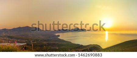 Beautiful sunrise in the mountains by the sea on the background of vineyards
