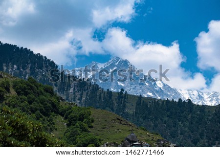 The Himalayas in all its might. Pictures taken from Himachal Pradesh. Mountains with a blue background. With few green trees from the forest.