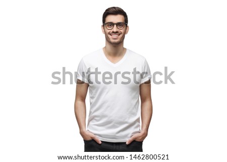 Yong man in casual t-shirt standing with hands in pockets, isolated on white background Royalty-Free Stock Photo #1462800521