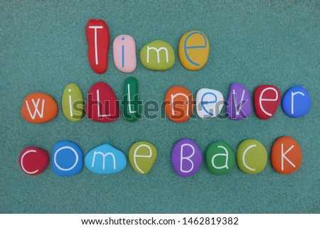 Time will never come back, message composed with colored stones over green sand