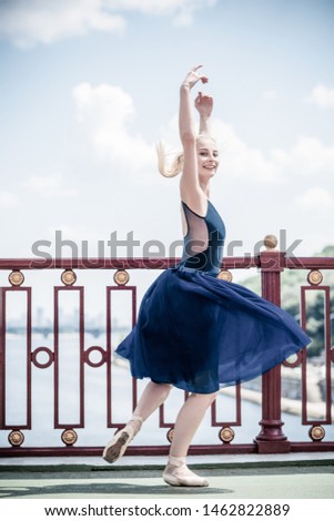 Young ballerina dancing in city streets, feeling breath of big city life and freedom