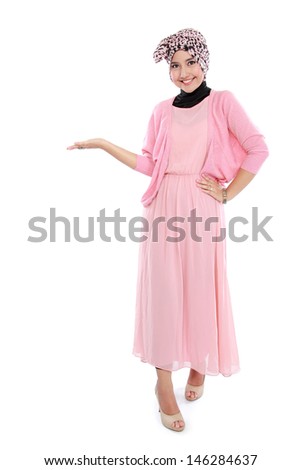 Portrait of standing young muslim woman showing blank area for sign or copyspace