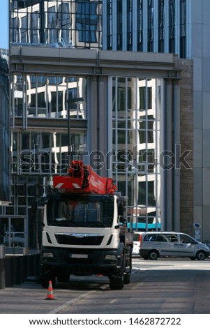A truck with a lift stands in front of modern office buildings in the city center of Frankfurt.
