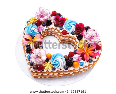 Heart shaped puff cake with fruit and flowers.