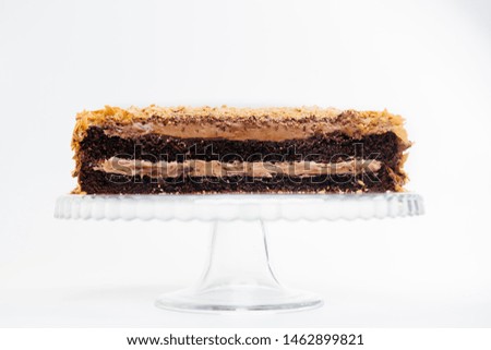 Chocolate cake with nuts. Half cake cut on white background.