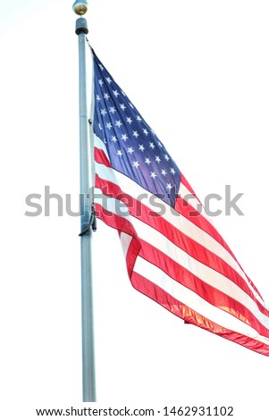United States flag waving in the air symbolizing patriotism with  red white and blue colors and Stars and Stripes