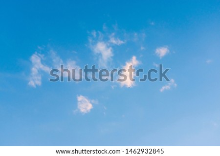 Blue sky with little white clouds in sunshine on a summer evening