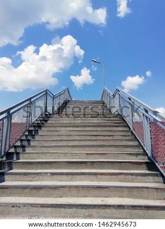 Stairs leading up. Stone staircase with iron handrails on a background of blue sky bottom view.