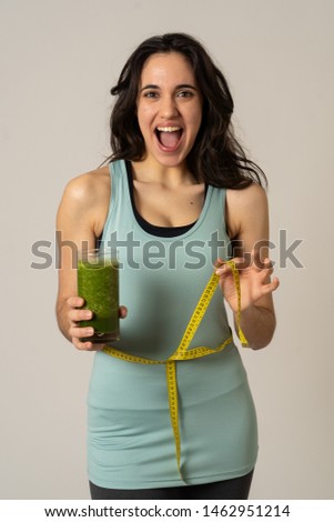 Fitness woman smiling happy with diet plan to loose weight; exercise and green vegetable smoothie healthy drink. In Beauty body care, Health Fitness Diet Nutrition and healthy Lifestyle concept.