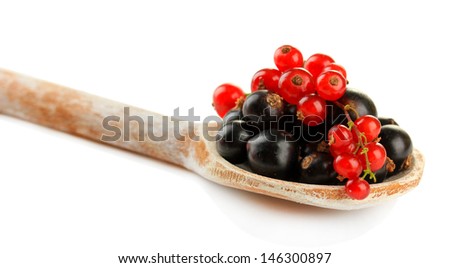 Red and black currant in wooden spoon isolated on white