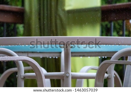 Tempered glass patio table in the rain, closeup  raindrop image.