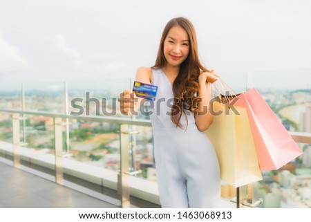 Portrait beautiful young asian woman happy and smile with credit card for shopping bag from department store mall