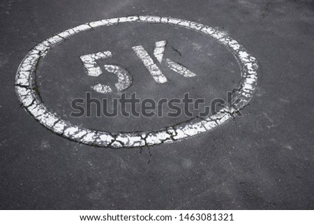 Road marking in a circle, five thousand dollars, five kilometre speed limit or 5K finance goal saving concept 