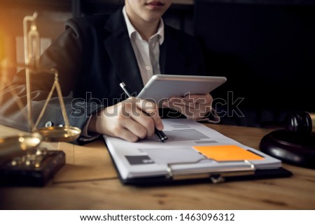 Justice and law concept. Female judge at a courtroom, working with document and laptop on table in modern office, Interface icon.