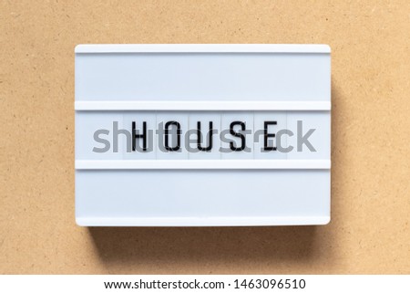 White lightbox with word house on wood background