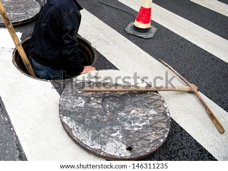 People working in a open manhole.