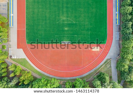 aerial view of empty green artificial football field with running track