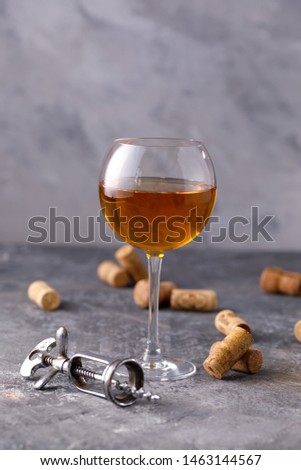 White wine in a glass. The concept of winemaking. Place under your text. Still life on a textural background. Close-up.