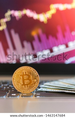 bitcoin, chart and us dollar. Finance trading. Dollar bills laying on a laptop with bitcoin charts on a blurred background. vertical photo.