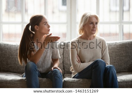 Annoyed grown up daughter expressing complaints to elderly mother annoyed females sit on couch, old stubborn mom dont want make concessions, different ages, generational gap, family conflict concept Royalty-Free Stock Photo #1463151269