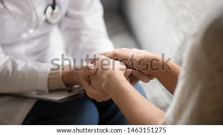 Close up horizontal image doctor in white uniform holding hands of female patient, showing support, gave professional aid psychological help, disease express of empathy and trusted specialist concept Royalty-Free Stock Photo #1463151275