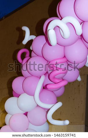 round pink and spiral white inflatable balloons at a party in the evening