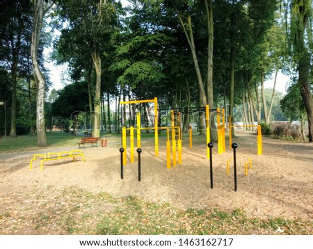 A classic outdoor gym surrounded by green trees.