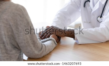 Black male doctor holding hands of female patient at meeting as women health medical care concept express trust support empathy about miscarriage, help hope in cancer disease therapy, close up view Royalty-Free Stock Photo #1463207693