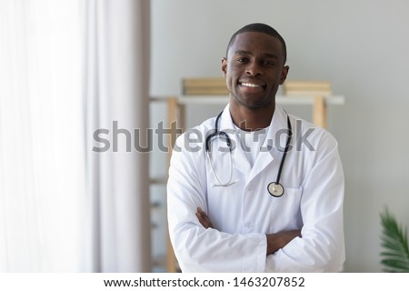 Smiling male african american professional young doctor stand arms crossed wear medical uniform looking at camera, happy confident black man general practitioner with stethoscope in office, portrait Royalty-Free Stock Photo #1463207852