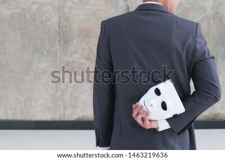 Businessman holding white mask in his hand dishonest cheating agreement.Faking and betray business partnership concept Royalty-Free Stock Photo #1463219636