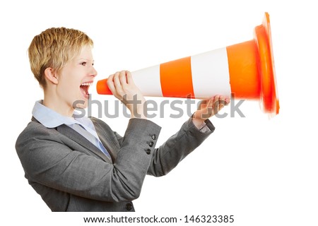 Young angry business woman screaming in a traffic cone