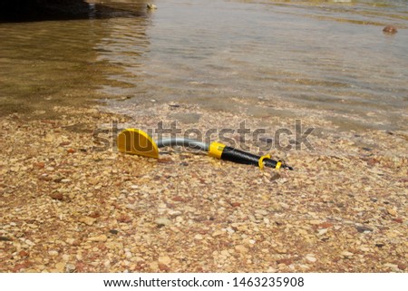 The photo of an underwater metal detector on the beach. Treasure searching and tourist adventure background.