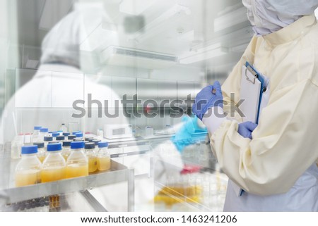 Lab worker in Protective Clothes and mask with gloves for doing research in foods factory or pharmaceutical. Double Exposure image with Laboratory Scientists Background.
