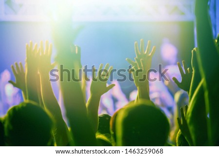 Concert crowd wave hand. Excited young people put hands up to favorite musician performing on stage. Group of happy fans partying on rock music festival. Royalty free musical photos for poster design