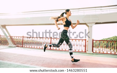 Strong body while healthy lifestyle. Side view full length photo of beautiful sporty woman when she is runs in trendy sport clothes.