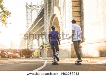 Young adults skating outdoors - Stylish skater couple training in a New York skate park, concepts about sport and ifestyle