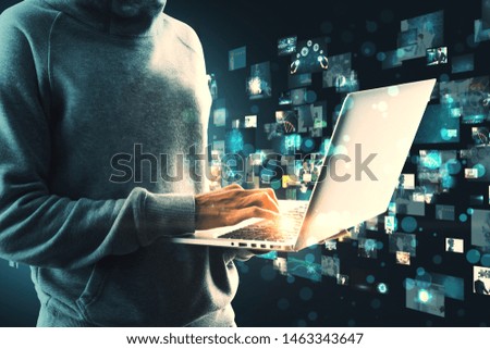 Person in hoodie and with laptop hacking creative digital picture gallery. Media and criminal concept
