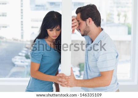 Divided couple are separated by white wall but holding hands Royalty-Free Stock Photo #146335109
