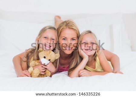 Portrait of a blonde woman in bed with her children
