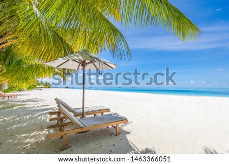 Tranquil beach landscape, summer vacation and holiday concept. Romantic honeymoon and wedding destination, two lounge chairs, umbrella, white sand, blue sea. Idyllic tropical beach view boost up color