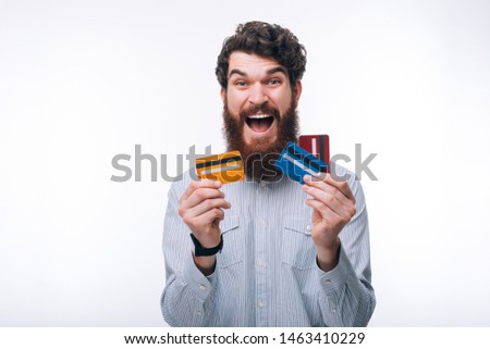 Photo of amazed man in casual holding different colorful credit cards