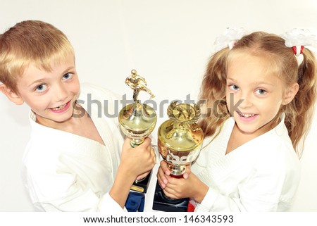 Girl and boy in a kimono with a championship winning in the hands of