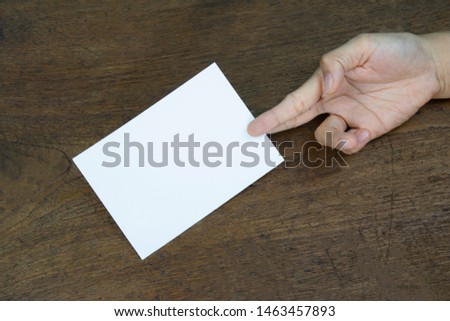 A6 Flyer / Postcard / Invitation Mock-Up - hands holding a blank flyer on a on a wooden table background. 