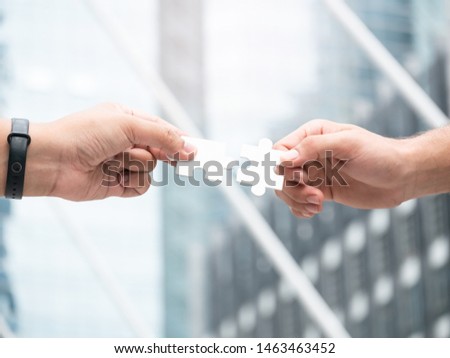 Close up of two hand trying to connect jigsaw puzzle. Business solutions, success and strategy concept