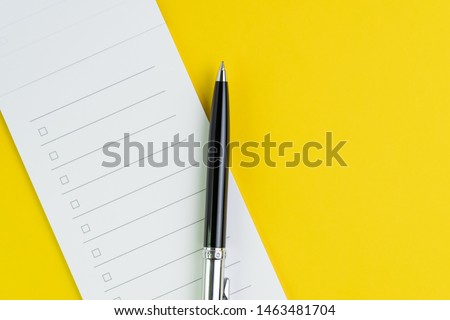Important business checklist, planning for shopping reminder or project priority task list, black pen on small notepad with checkbox on solid yellow background with copy space. Royalty-Free Stock Photo #1463481704