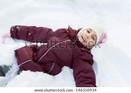 Girl lying in the snow and smiling