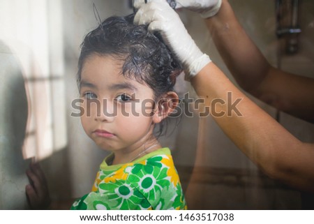 little girl Washing out Head lice  