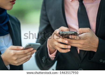 Muslim Couple on their smartphone. Texting and checking out their social media
